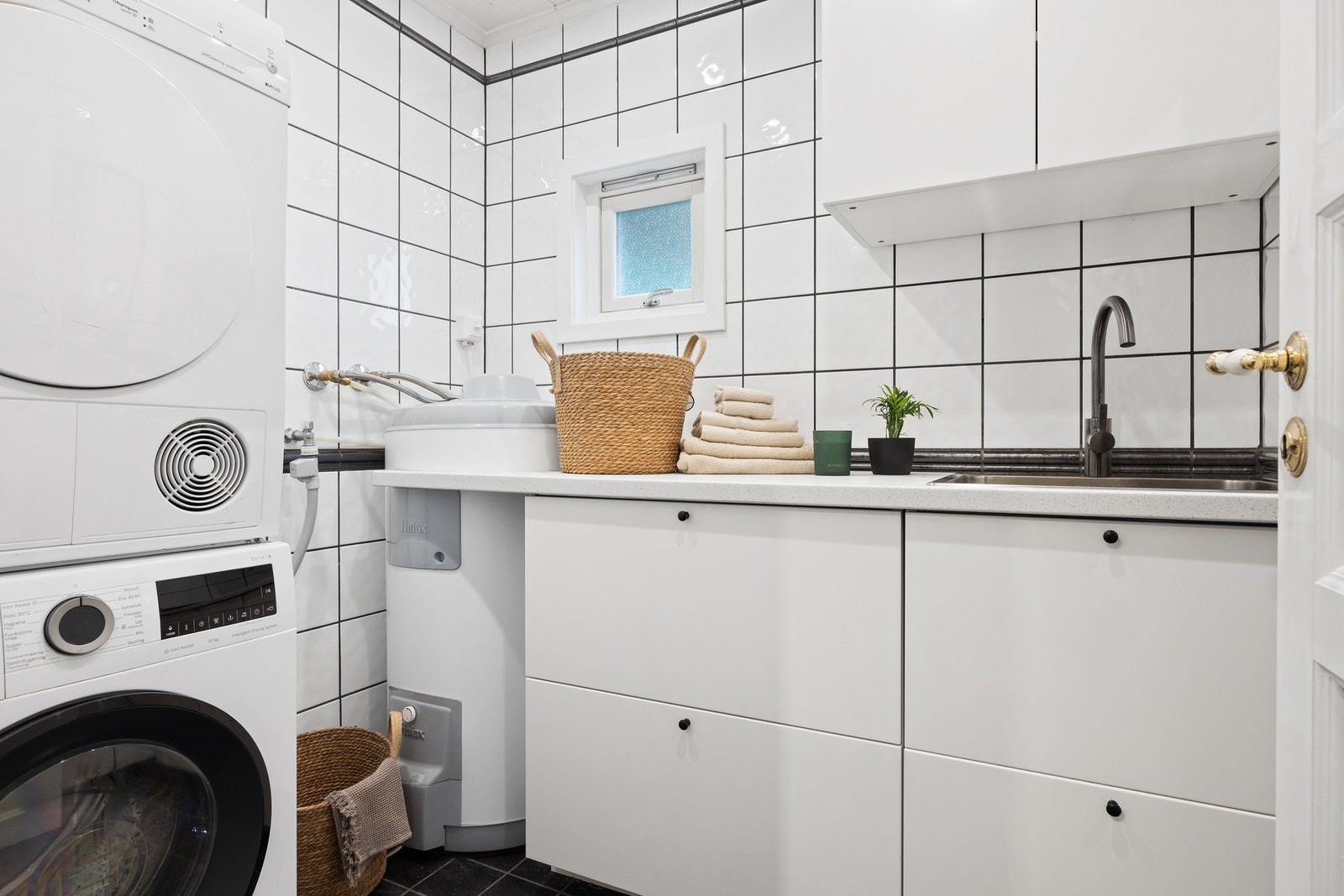 Praktisk flislagt vaskerom med varmekabler i gulv og downlights i himling Galleribilde