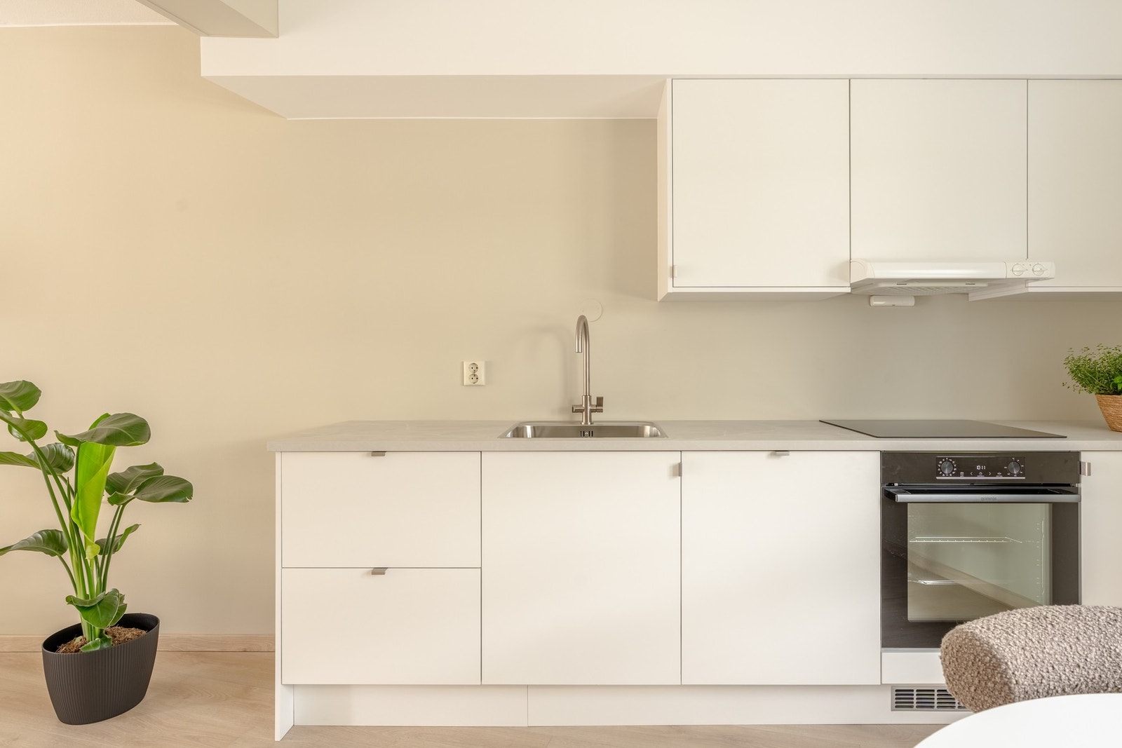 Kjøkkeninnredning med slette fronter og laminat benkeplate med nedfelt vask av stål. Galleribilde