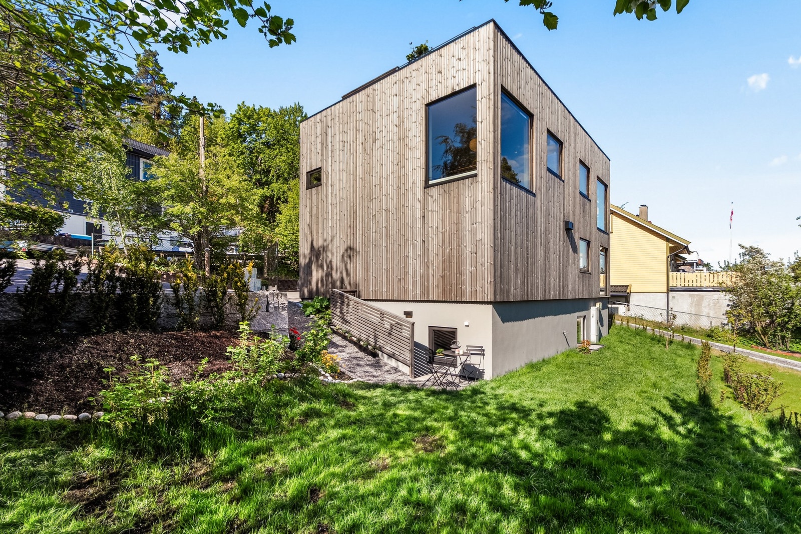 Tomten er ellers pent opparbeidet med gressplen, pryd- og bærbusker og beplantning. Galleribilde