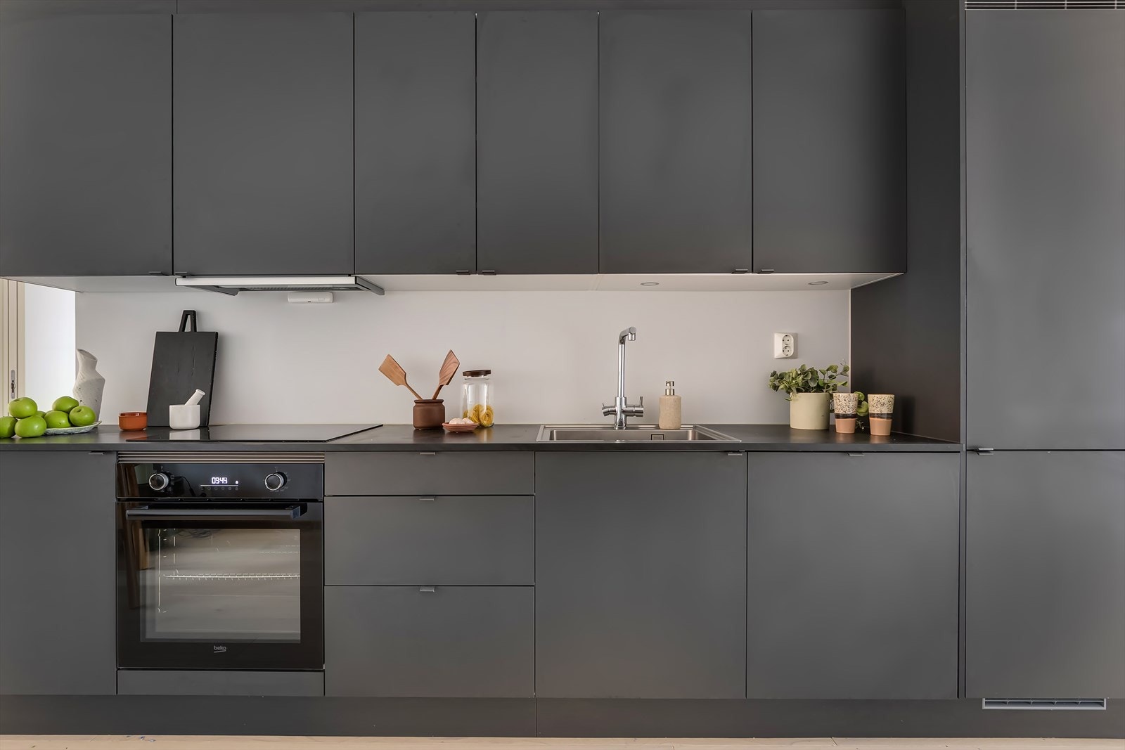 Innredningen består av en tidløs og stilren kombinasjon av sorte fronter og mørk, laminert benkeplate. Induksjon platetopp, stekeovn, oppvaskmaskin og kjøl frys er integrert i innredningen. Galleribilde