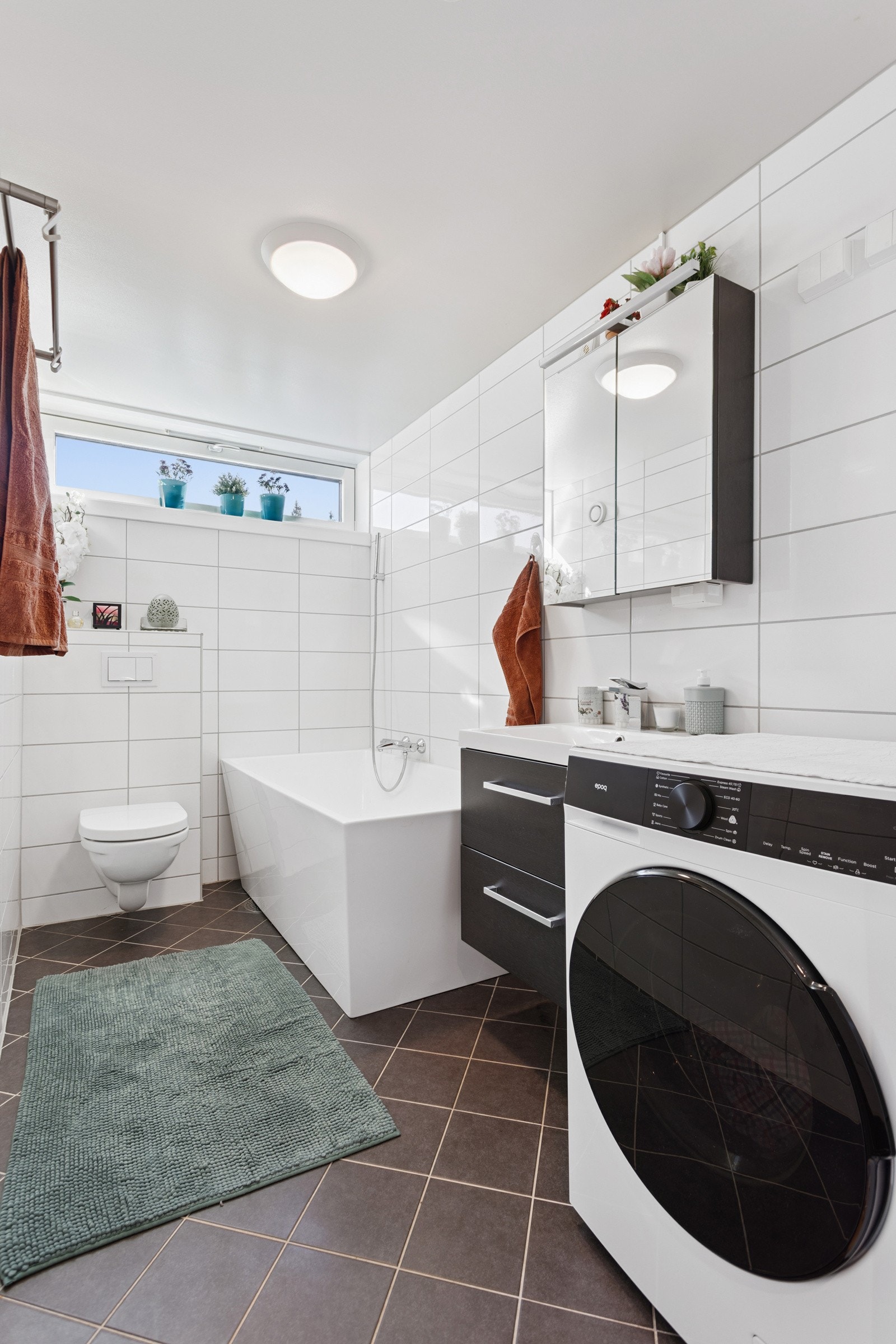 Badet består av badekar, servant m/underskap, overskap m/speilfronter og overlys, veggklosett og opplegg for vaskemaskin. Galleribilde