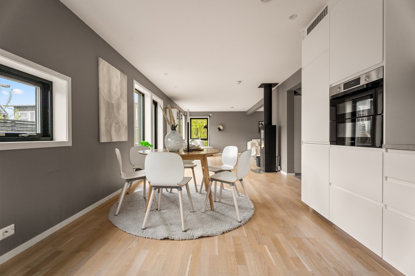Moderne kjøkken med hvite, slette fronter og laminat benkeplate. Galleribilde