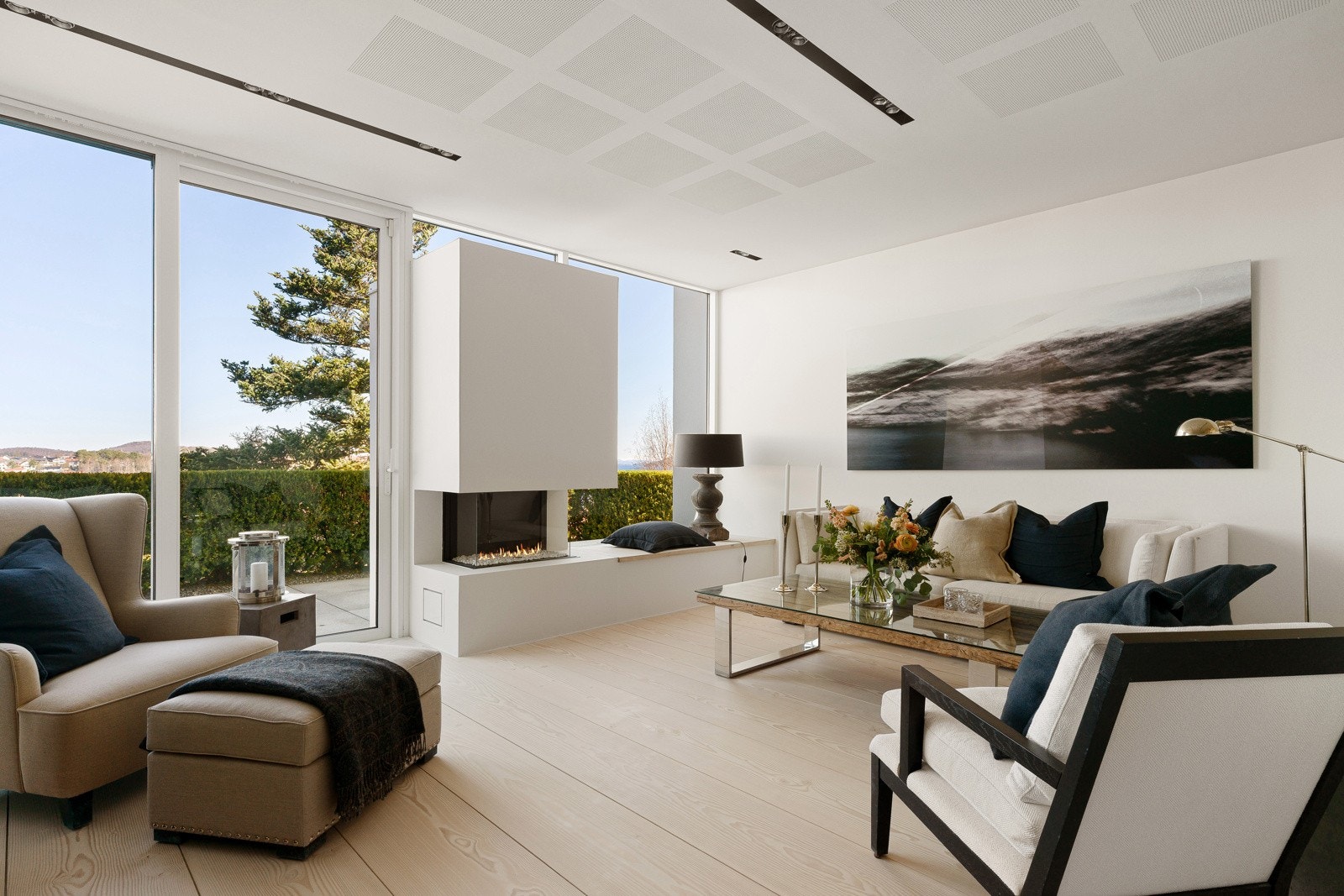 Fra gangen kommer man til en lys, men lun stue. Fra her er det direkte utgang til uteorådet i første etasje, og stuen har et flott landskapsfotografi spesialdesignet for huset. Galleribilde