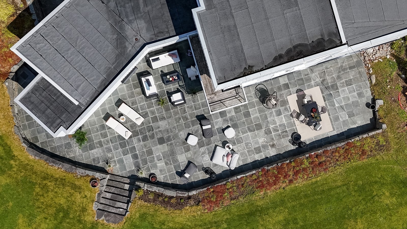 Terrasseplatting i naturstein, opparbeidet med solide natursteinsmurer som gir uteplassen tyngde og karakter Galleribilde