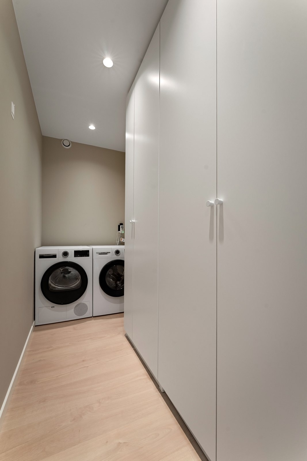 Omkledningsrom inn fra entré med stor garderobe. Opplegg for vaskemaskin. Galleribilde