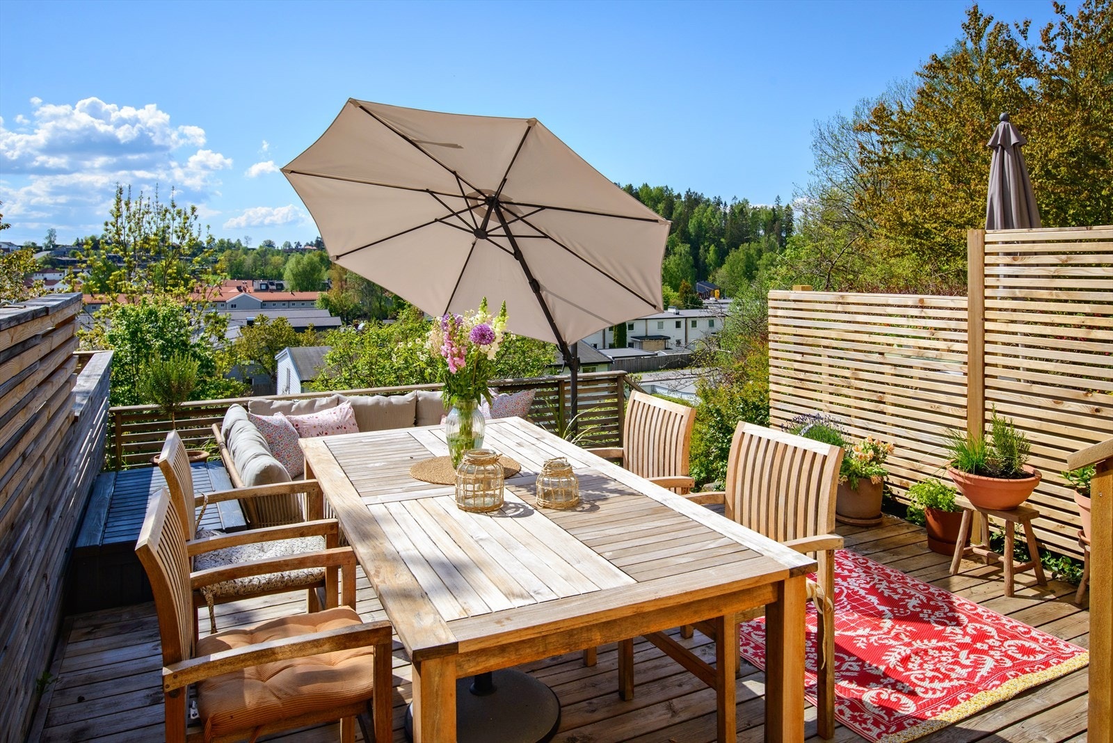 Terrassen kan naturlig deles inn i flere soner med spisebord og loungeområde Galleribilde