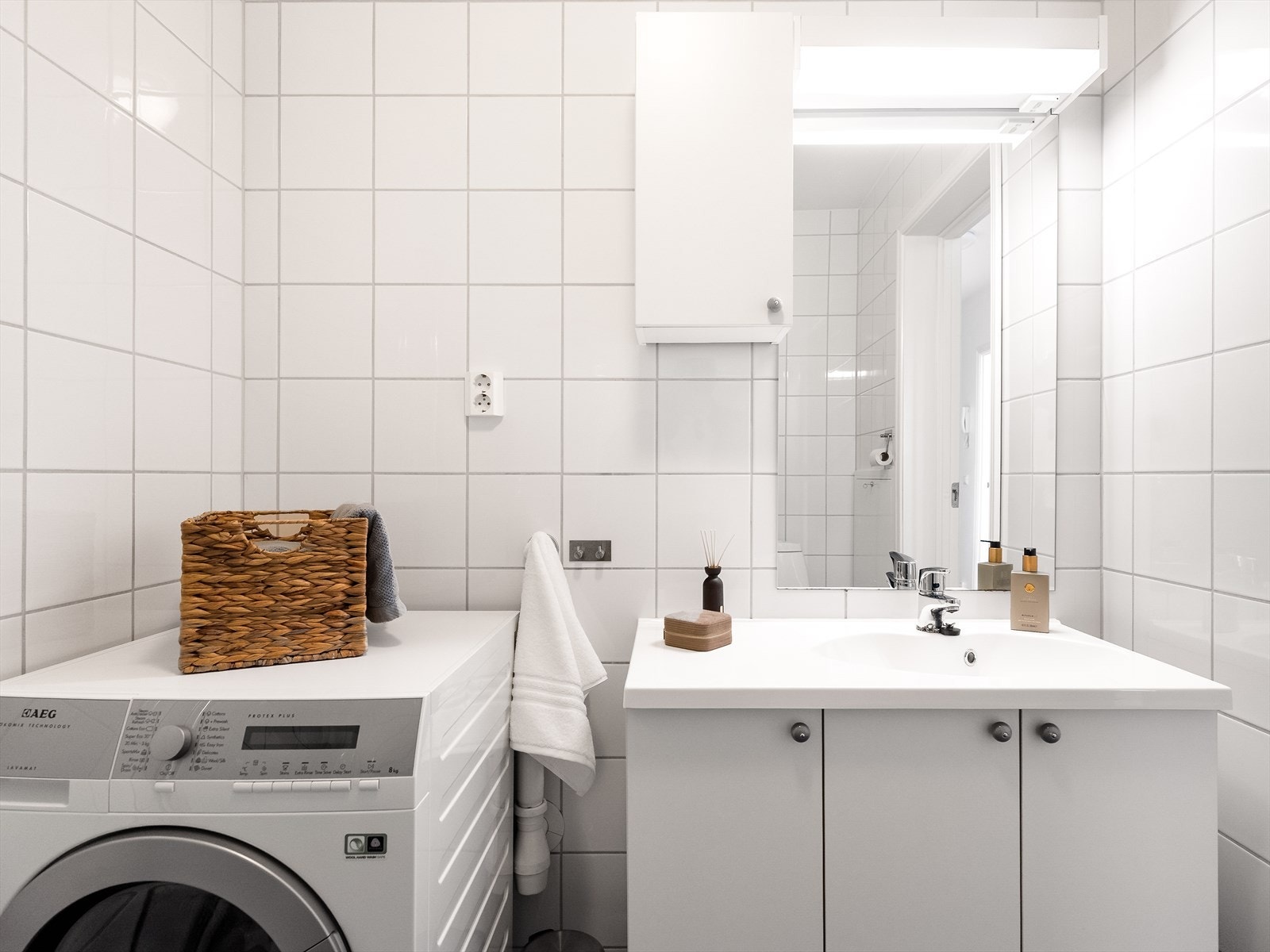 Badet har opplegg for vaskemaskin, klosett, enkel servant og dusjhjørne med foldbare glassdører. Galleribilde