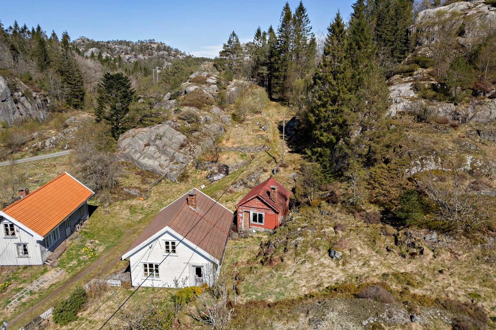 Våningshuset og uthusene ligger i et skrånende terreng. Galleribilde