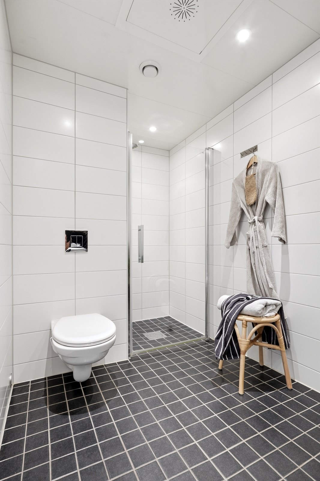 Badet er utstyrt med vegghengt toalett, dusj med innfellbare glassdører og opplegg for vaskemaskin. Galleribilde