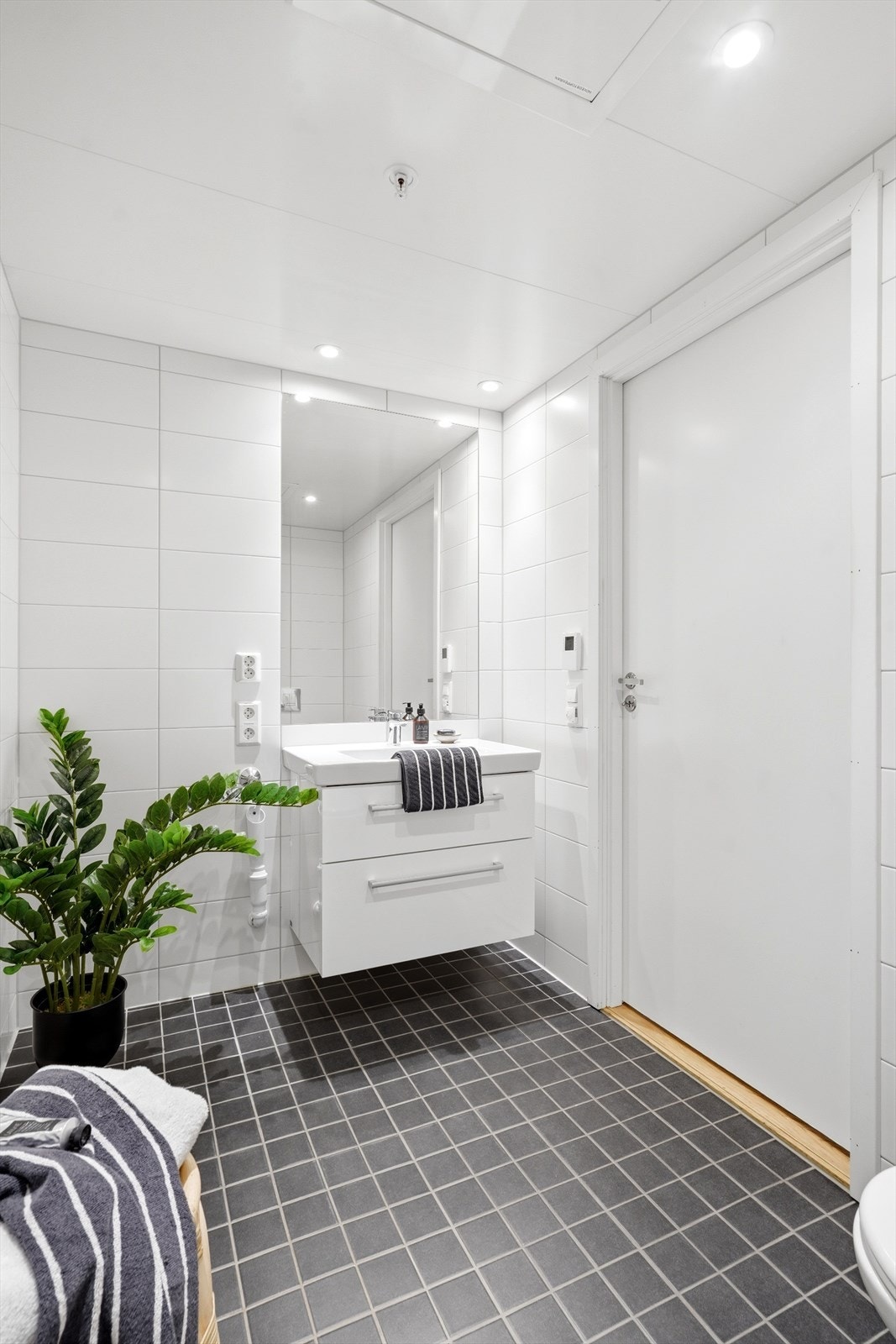 Praktisk innredning med servant, speil og belysning. Badet har også balansert ventilasjon. Galleribilde