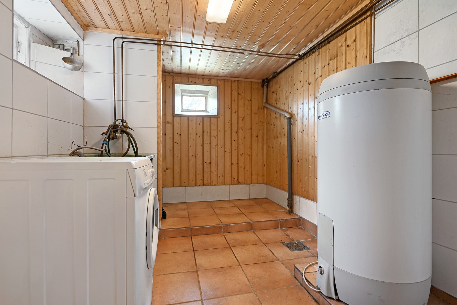 Vaskerom med fliser på gulv samt panel og fliser på veggene. Galleribilde