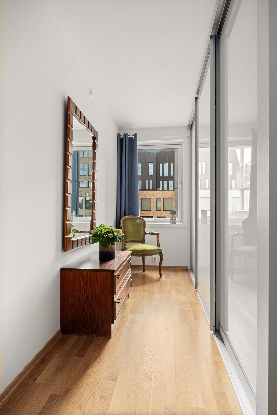 En hel vegg er dedikert til en romslig skyvedørsgarderobe. Galleribilde