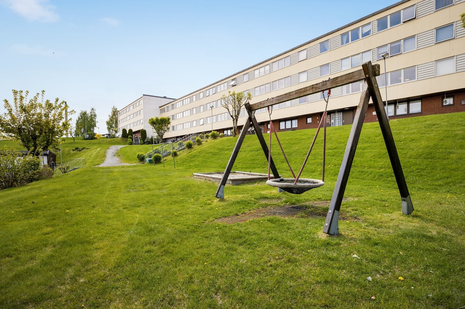Tomten er fellesareal som er opparbeidet med plen, diverse beplantning, huske og sandkasse tilrettelagt for barnas lek. Galleribilde