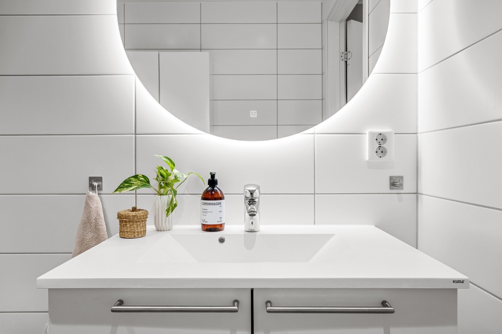 Badet er utstyrt med vegghengt WC, stor servant, dusjhjørne med innfellbare dører og opplegg for vaskemaskin. Galleribilde
