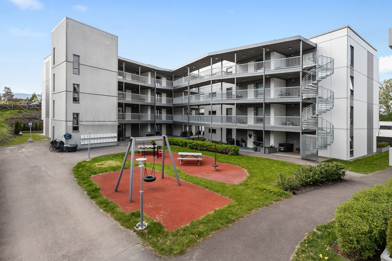 Tomten er opparbeidet med asfalterte internveier, biloppstillingsplasser, plenareal, diverse beplantning og lekeområde Galleribilde