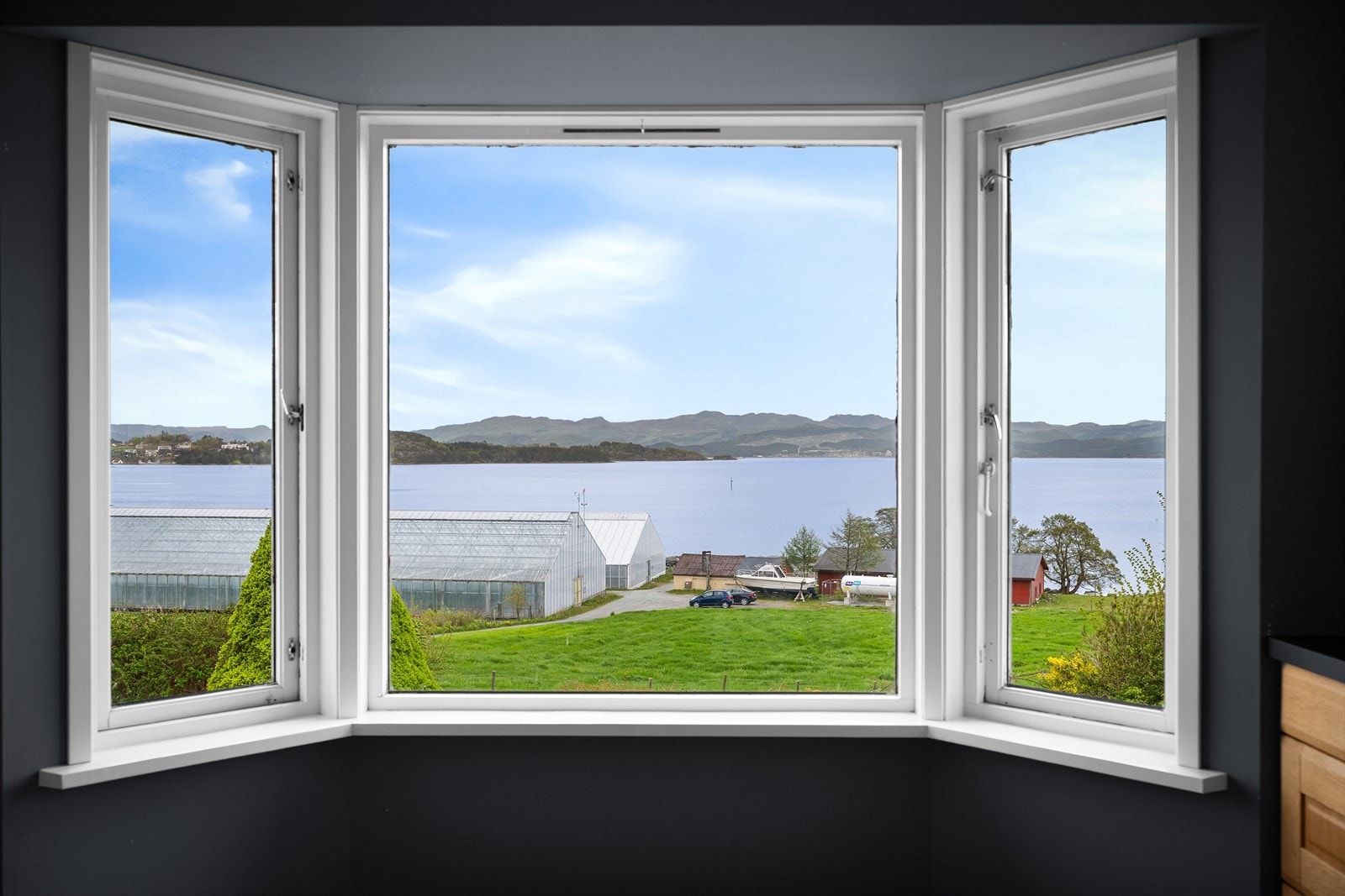 Fra karnappvinduet på kjøkkenet er det utsikt over landskapet og sjøen. Galleribilde