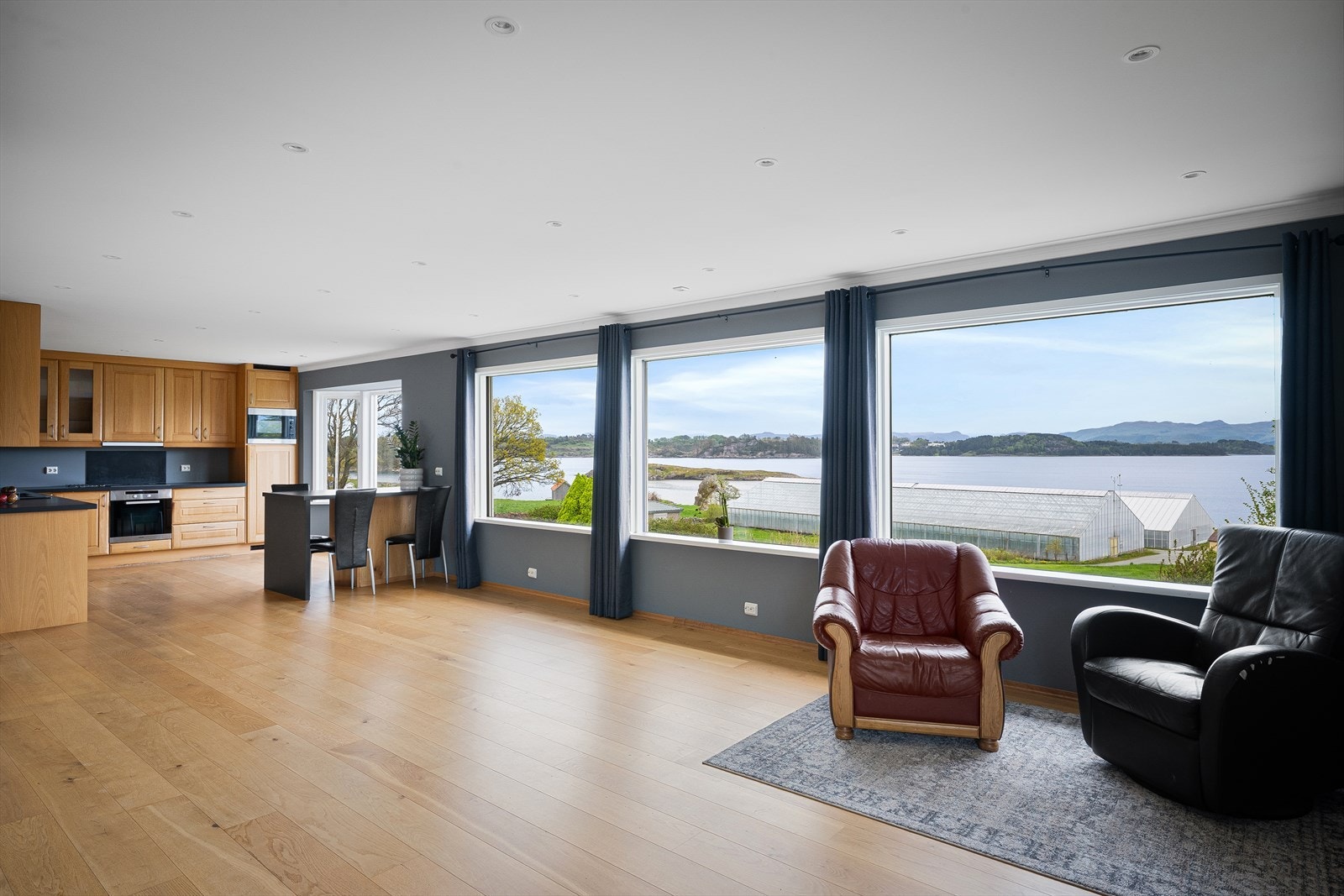 Den åpne stuen har god plass til både sofagruppe og spisebord, med gjennomgående parkett på gulvet. Galleribilde