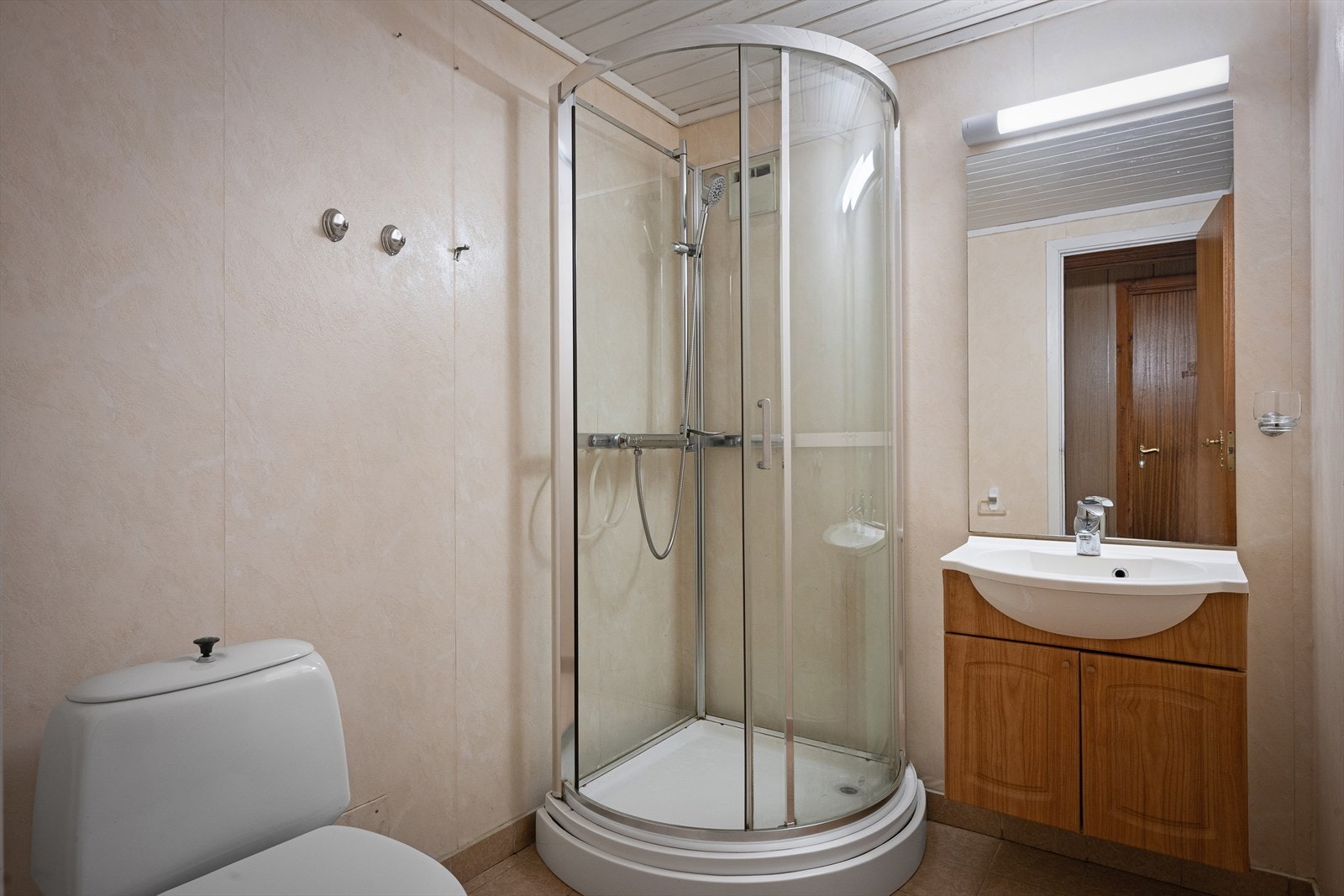 Badet i kjelleren har fliser med varme på gulv, våtromstapet og dusjkabinett. Det er også her klargjort for vannbåren gulvvarme. Galleribilde