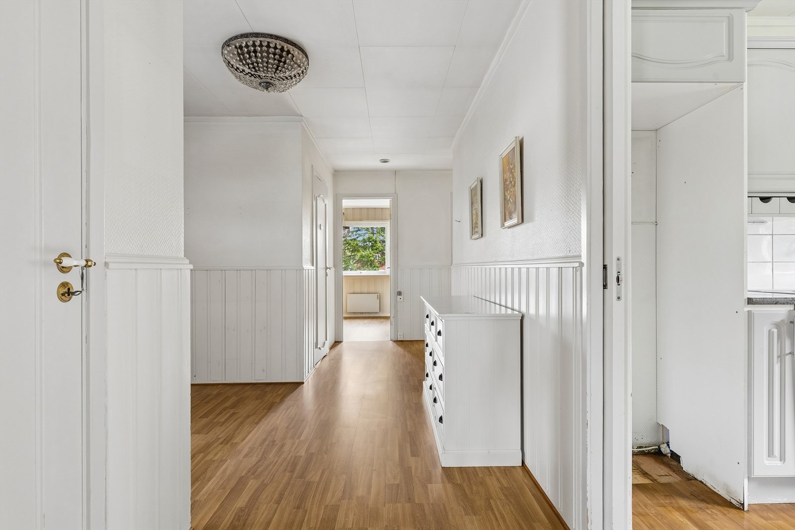 Gangen binder sammen flere av boligens rom. Overflatene består hovedsakelig av laminat på gulv og panel på veggene. Galleribilde