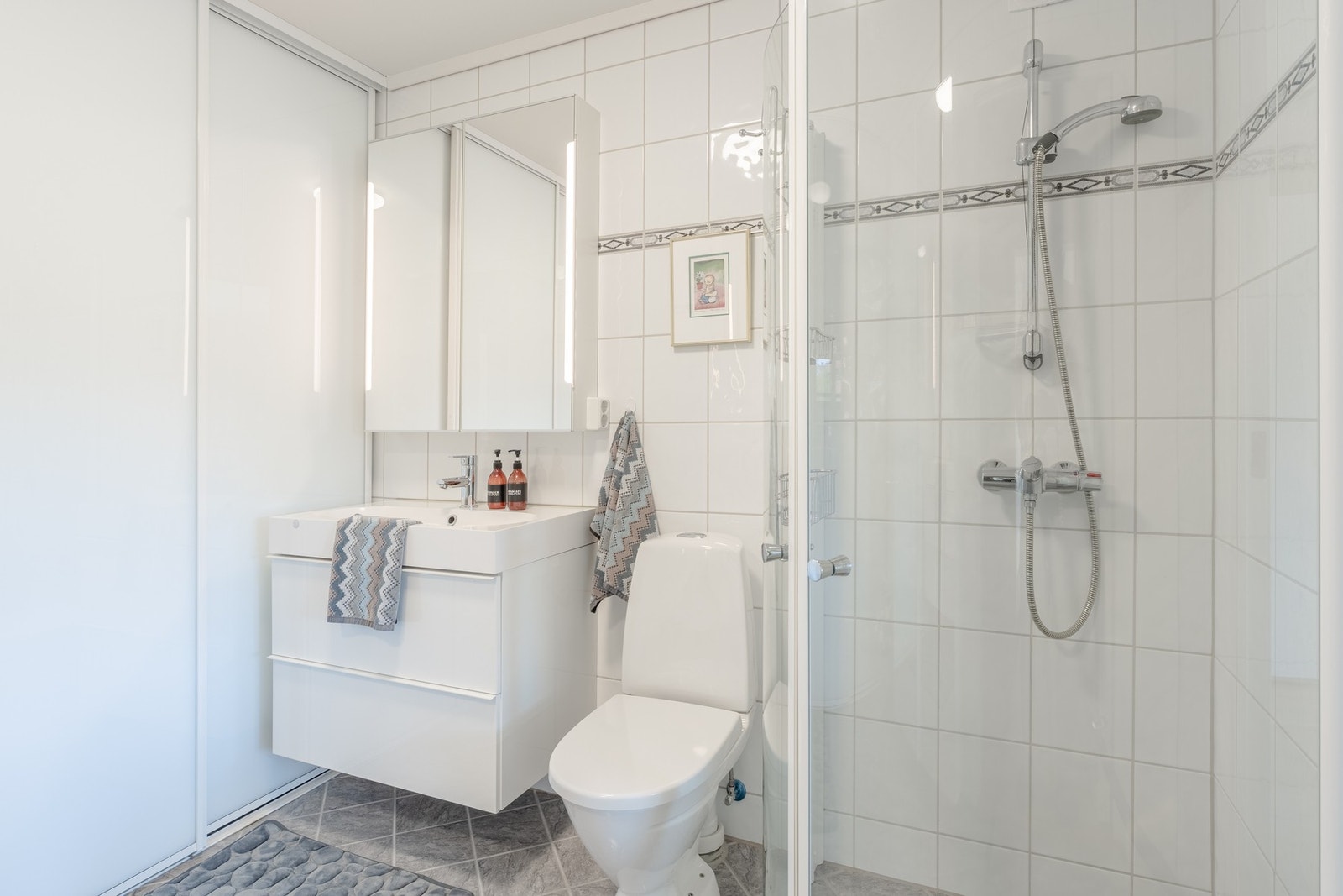 Badet måles til 5 kvm. og er helfliset med innfelte downlights i himling og underliggende varmekabler. Galleribilde