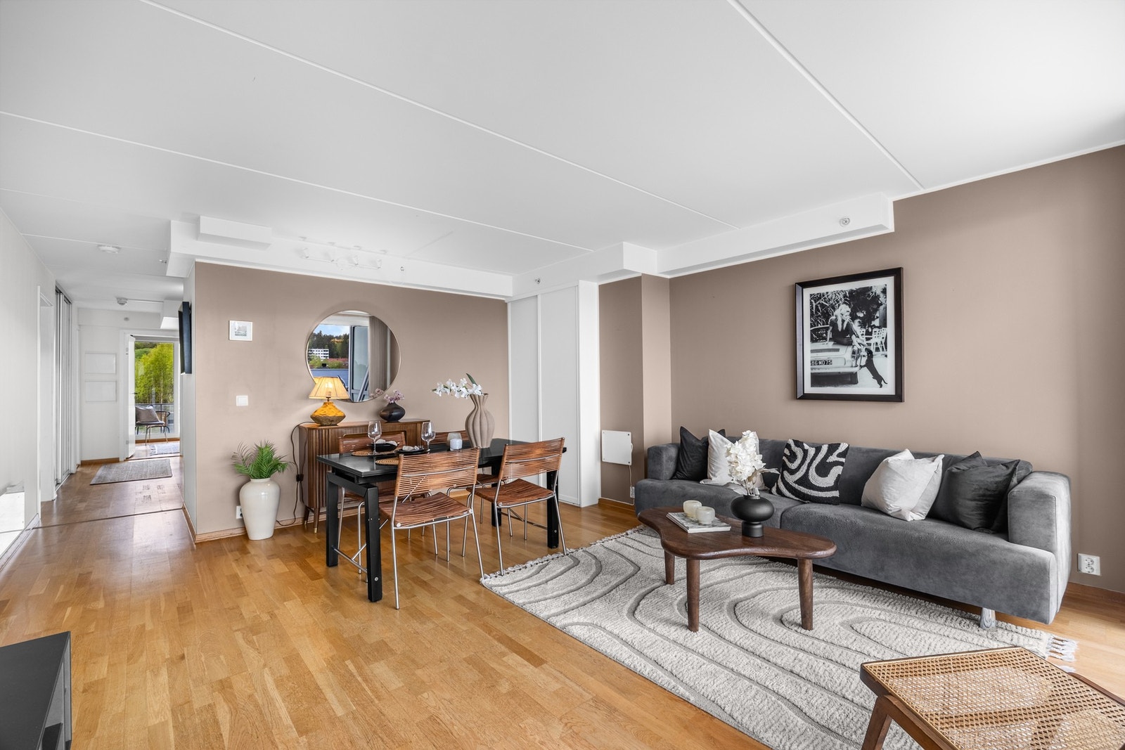I stuen er det plass til både sofagruppe og spisestue. Planløsningen er gjennomgående og lyse, tiltalende fargevalg gir leiligheten en god atmosfære Galleribilde