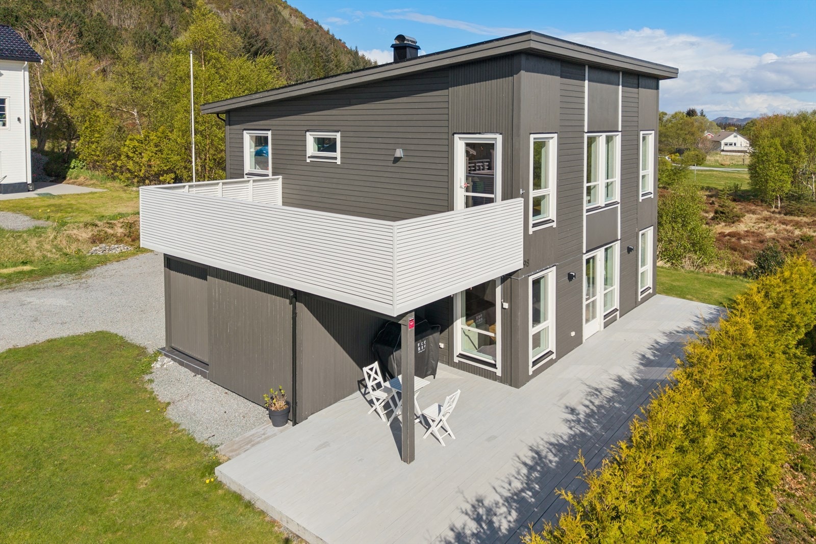 Eiendommen har en stor, gruset gårdsplass med parkering for flere biler og installert elbillader. Galleribilde