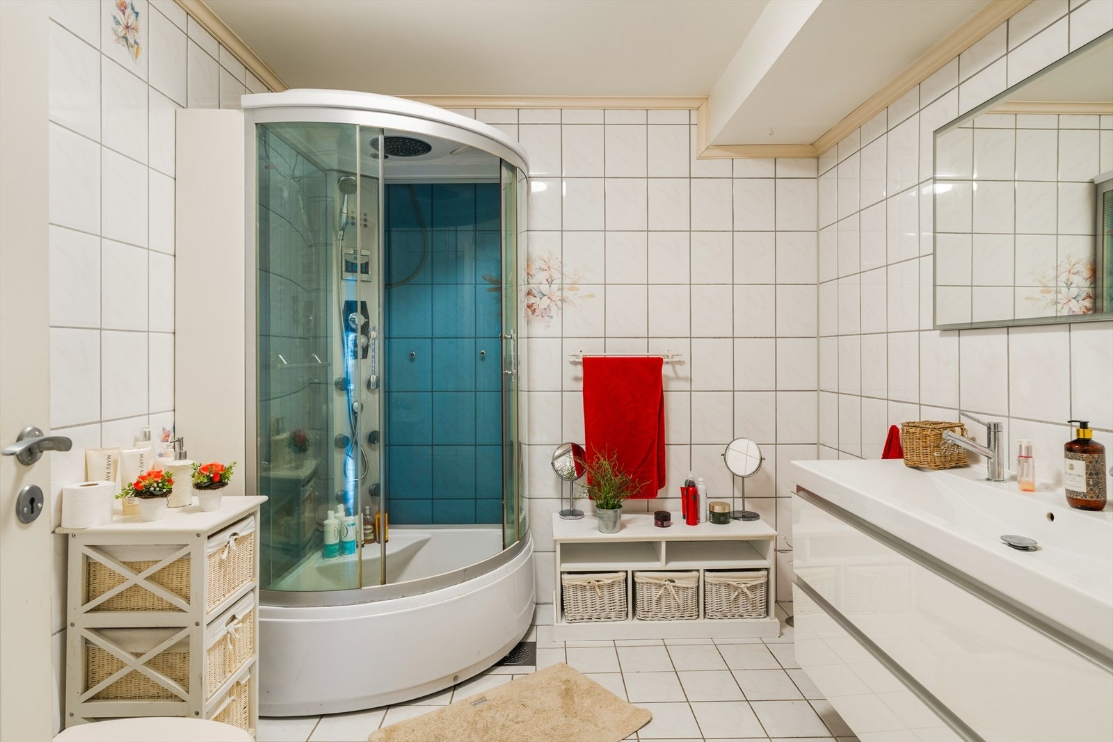 Badet er innredet med dobbel servant i møbel, dusjkabinett og toalett Galleribilde