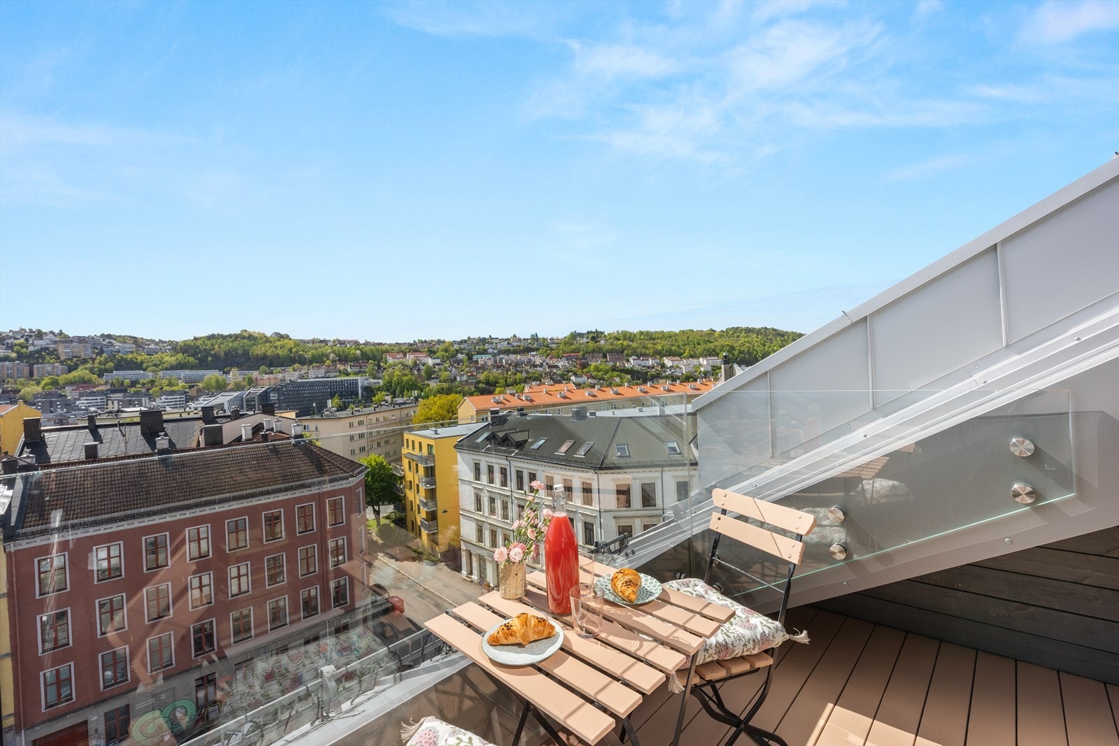 Her får du en fin kombinasjon av byliv, sol og åpen himmel. Det godt med oppbevaringsplass under skråtaket på begge sider av terrassen. Galleribilde