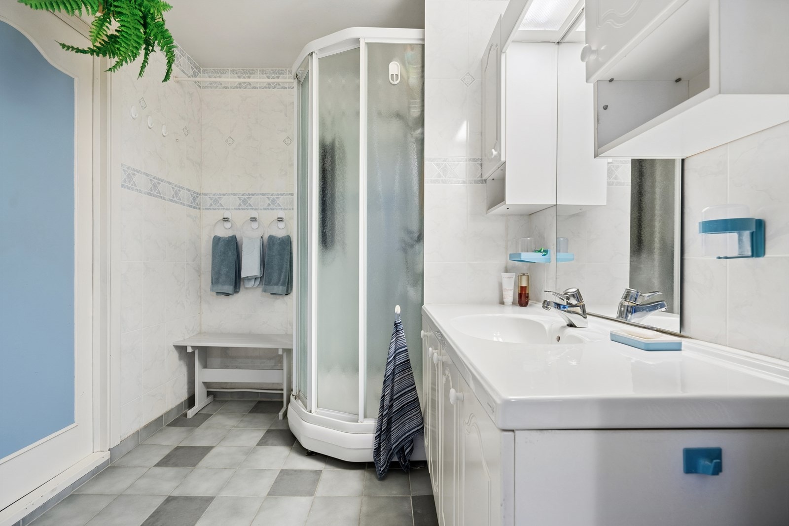 Badet lyst og er innredet med dusjkabinett, servant med underskap, speil og belysning. Galleribilde