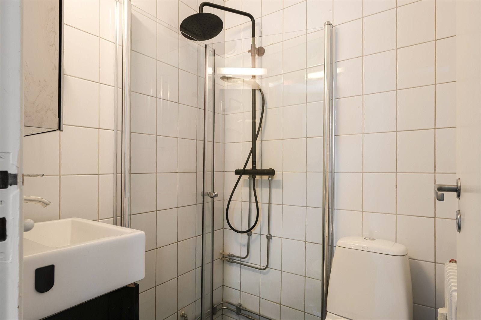 Rommet er innredet med servant med underskap, speilskap, wc og dusjsone med innfellbare dusjdører. Galleribilde