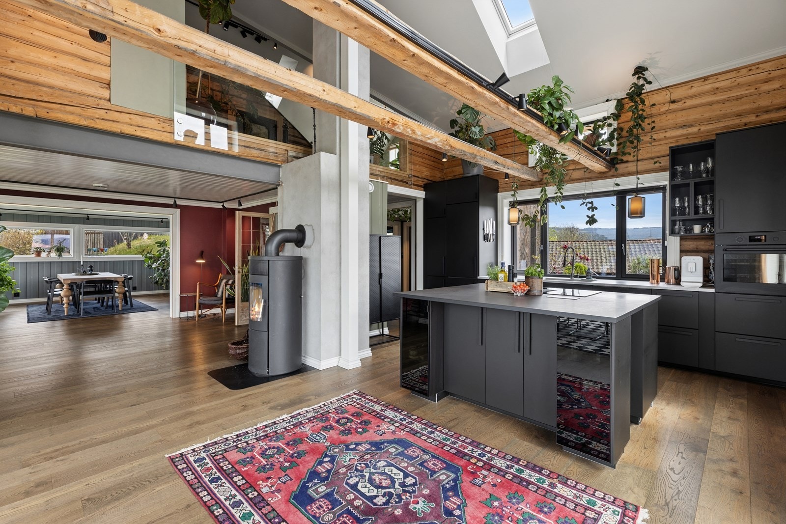 Det luftige kjøkkenet består av en moderne IKEA innredning i kontrast til de originale tømmerveggene. Galleribilde