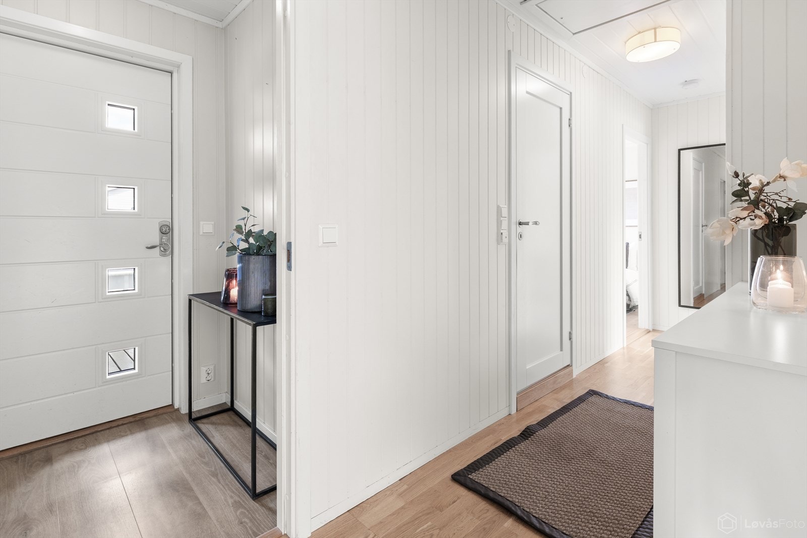 Velkommen inn til en lys og innbydende entré som gir et godt førsteinntrykk av boligen. Her er det plass til å henge fra seg yttertøy og sko før man beveger seg videre inn i hjemmet. Galleribilde