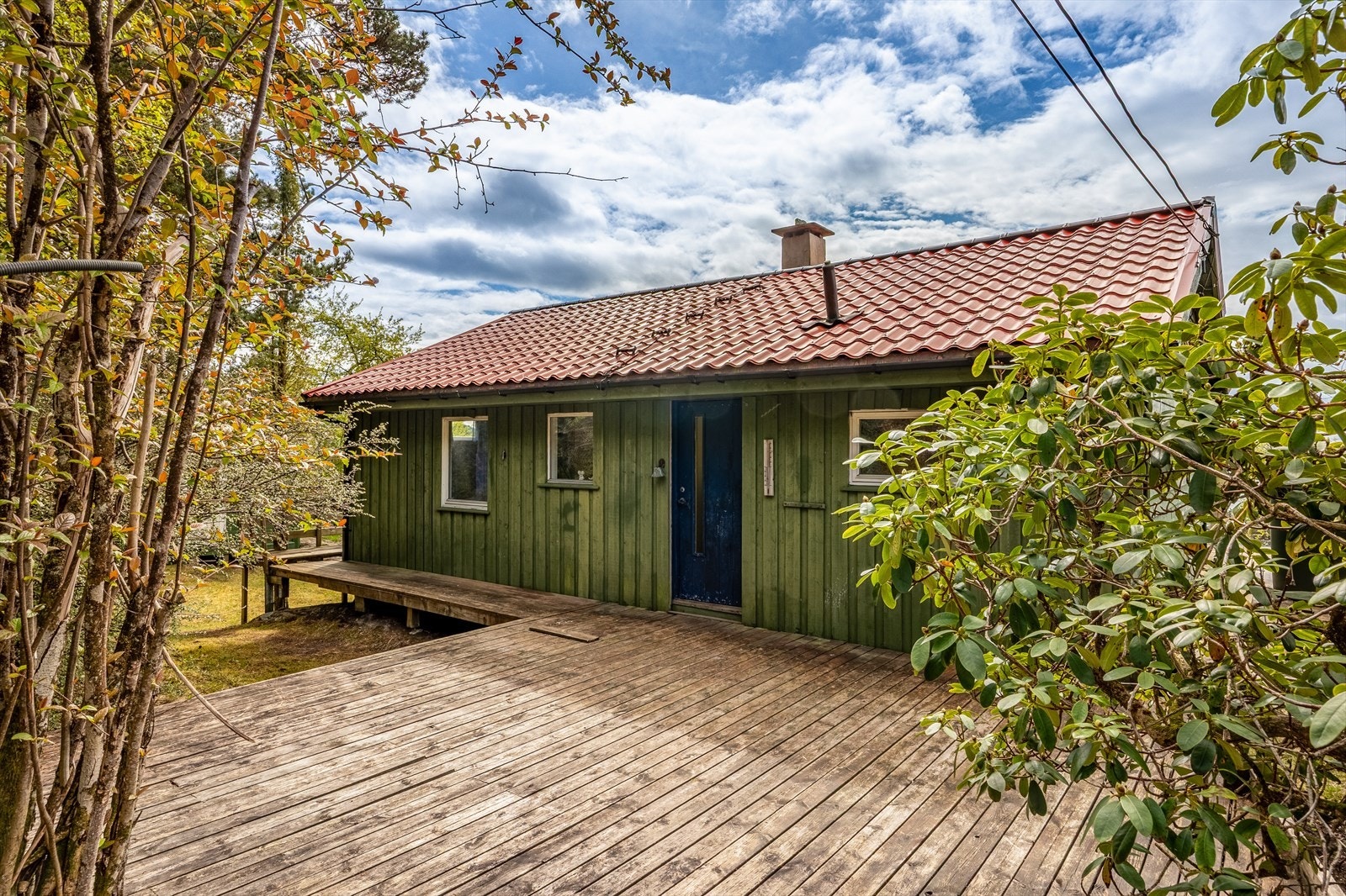 Fritidsboligen har terrasse rundt store deler av boligen og et skjermet inngangsparti. Galleribilde