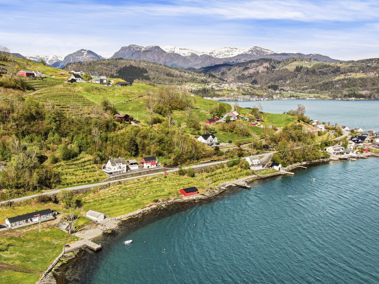 En vakker sjøeiendom i Hardanger med både plommetrær, strandlinje, naust og brygge Galleribilde
