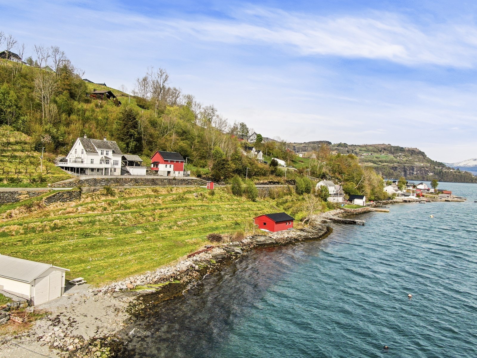Eiendommen har meget godt potensiale nede ved sjøen. Her ser man bryggen på høyre side av naustet Galleribilde