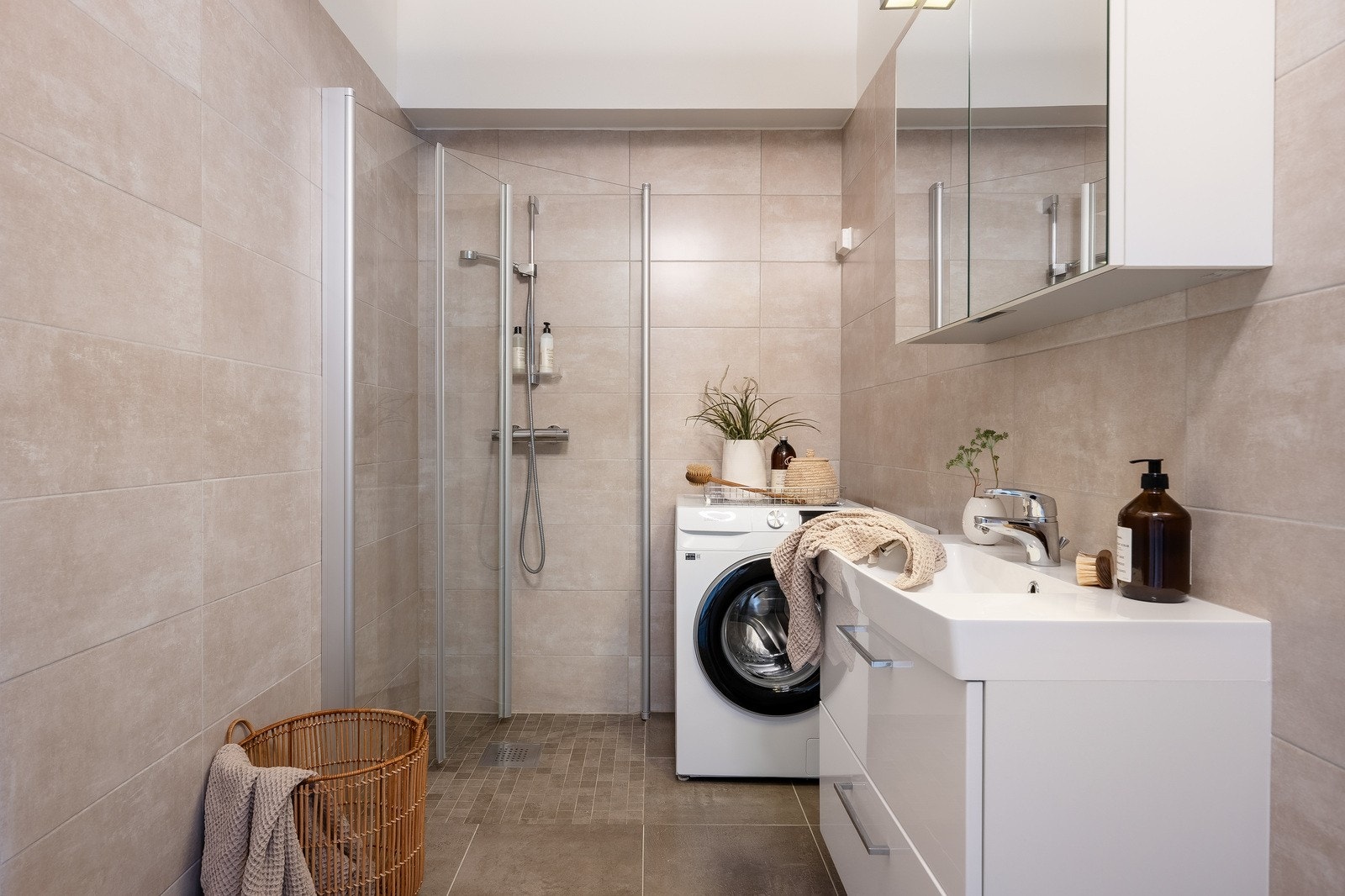 Leiligheten har 2 moderne bad med eksklusivt preg, kledd i elegante storformatfliser som skaper en harmonisk og spa-lignende atmosfære Galleribilde