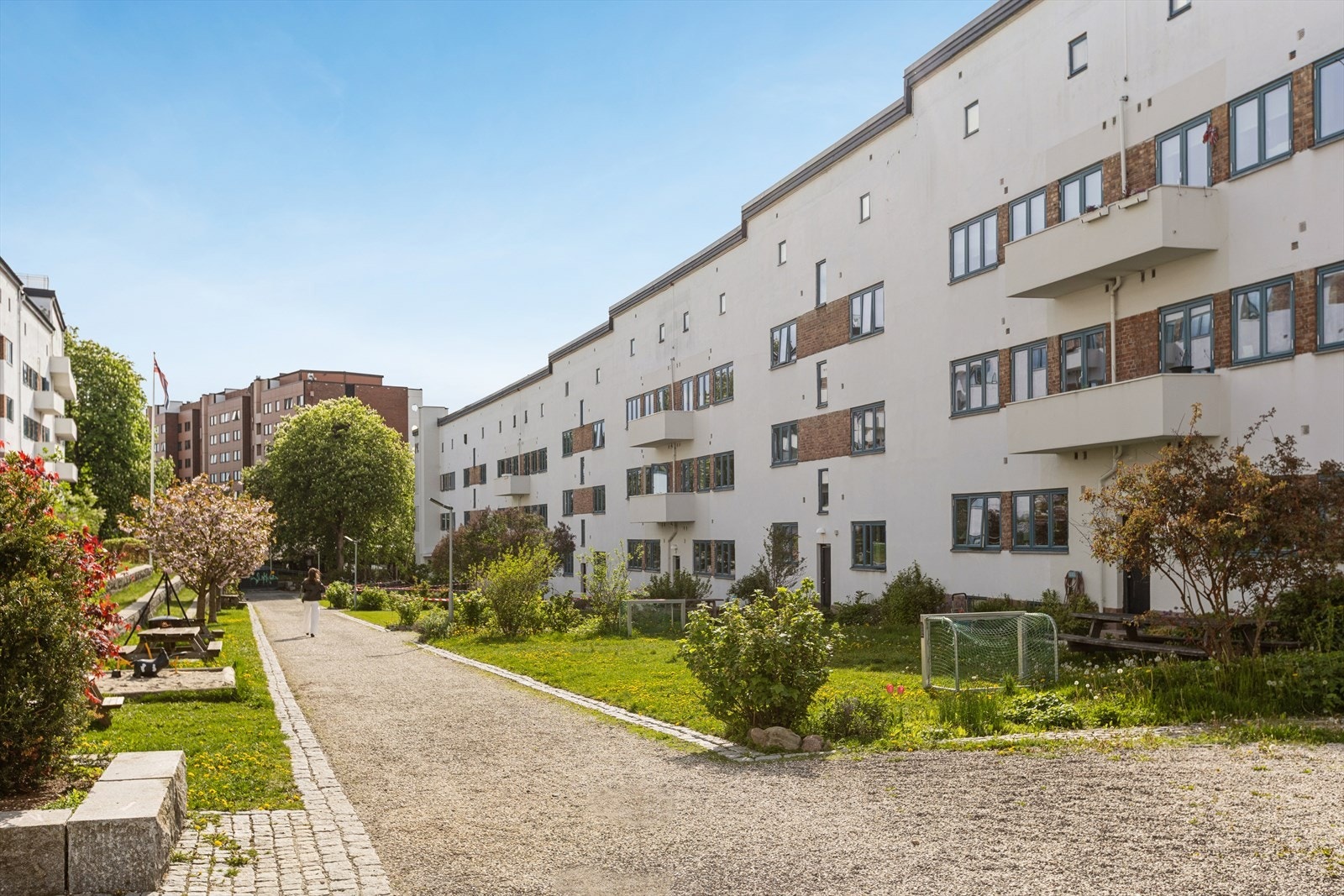 Dette er bakgård på Torshov-nivå. Her får du grønne plener, trær og sittegrupper som gir ekte parkfølelse rett utenfor døra. Galleribilde