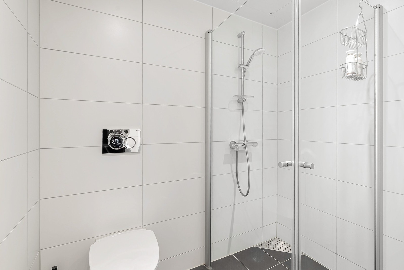 Det er lys innredning med servantinnredning, dusjhjørne og opplegg for vaskemaskin. Galleribilde