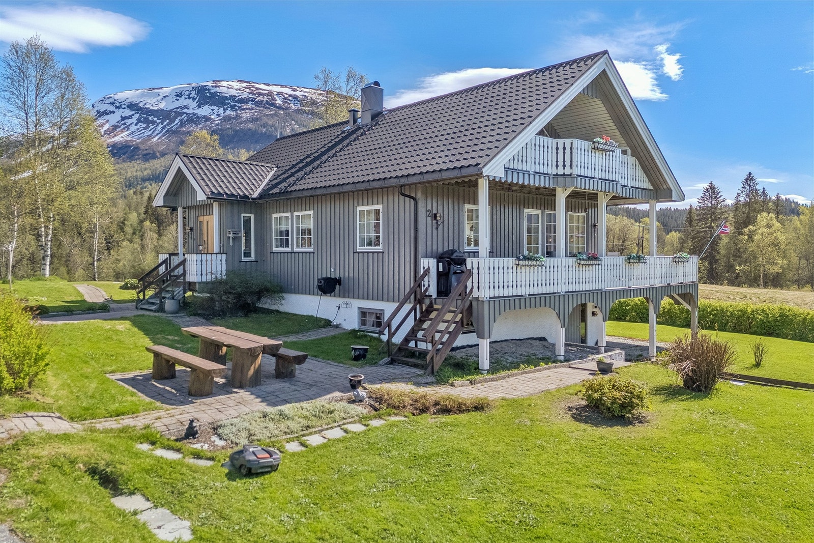 Eiendommen har en opparbeidet tomt med plen og beplantning, samt en stor terrasse og veranda. Galleribilde