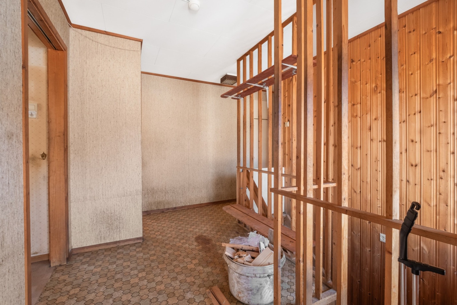Hall med lakkert tretrapp som forbinder de to etasjene. Galleribilde