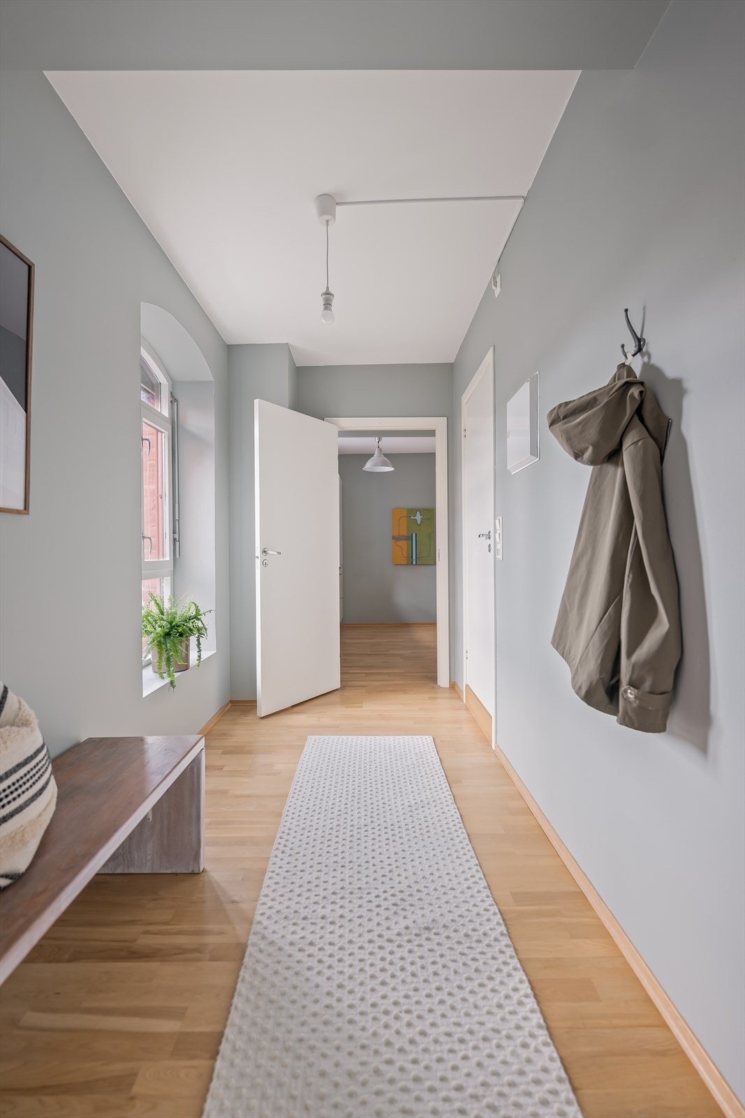 Romslig og innbydende entré med plass til oppbevaringsmøbler. Galleribilde