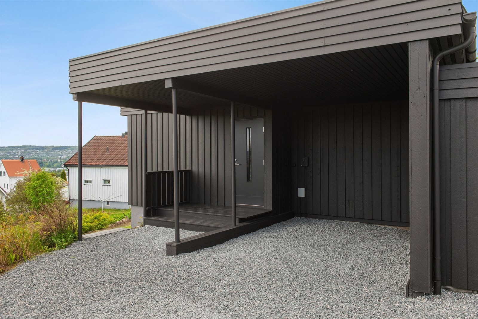 Overbygd inngangsparti og carport. Fasaden ble malt i 2026. Galleribilde