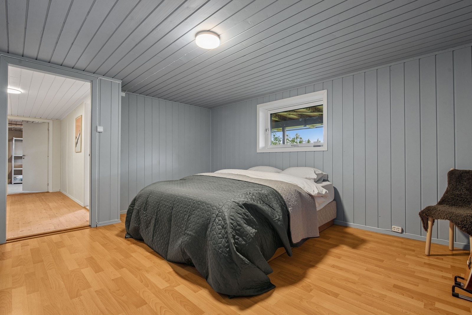 Rommet har panel på veggene og laminat på gulvet. Galleribilde