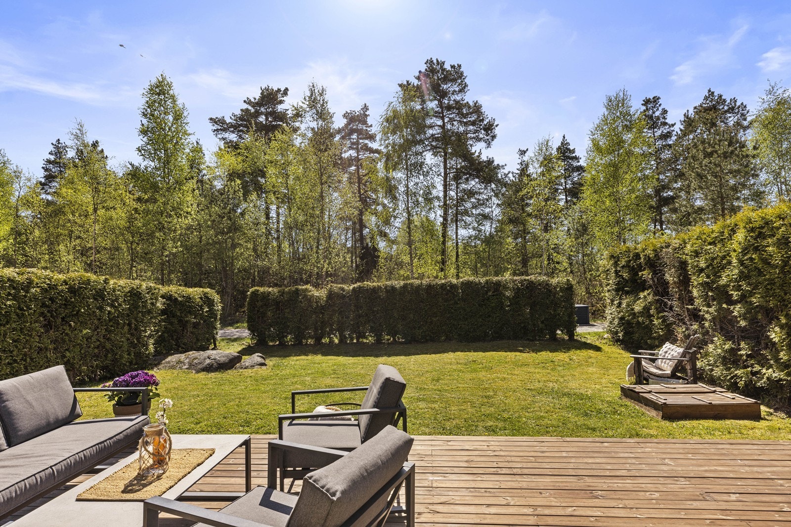 Stor, sørvendt terrasse på 34 m² med direkte utgang fra stuen, og en skjermet hage omkranset av hekk. Galleribilde
