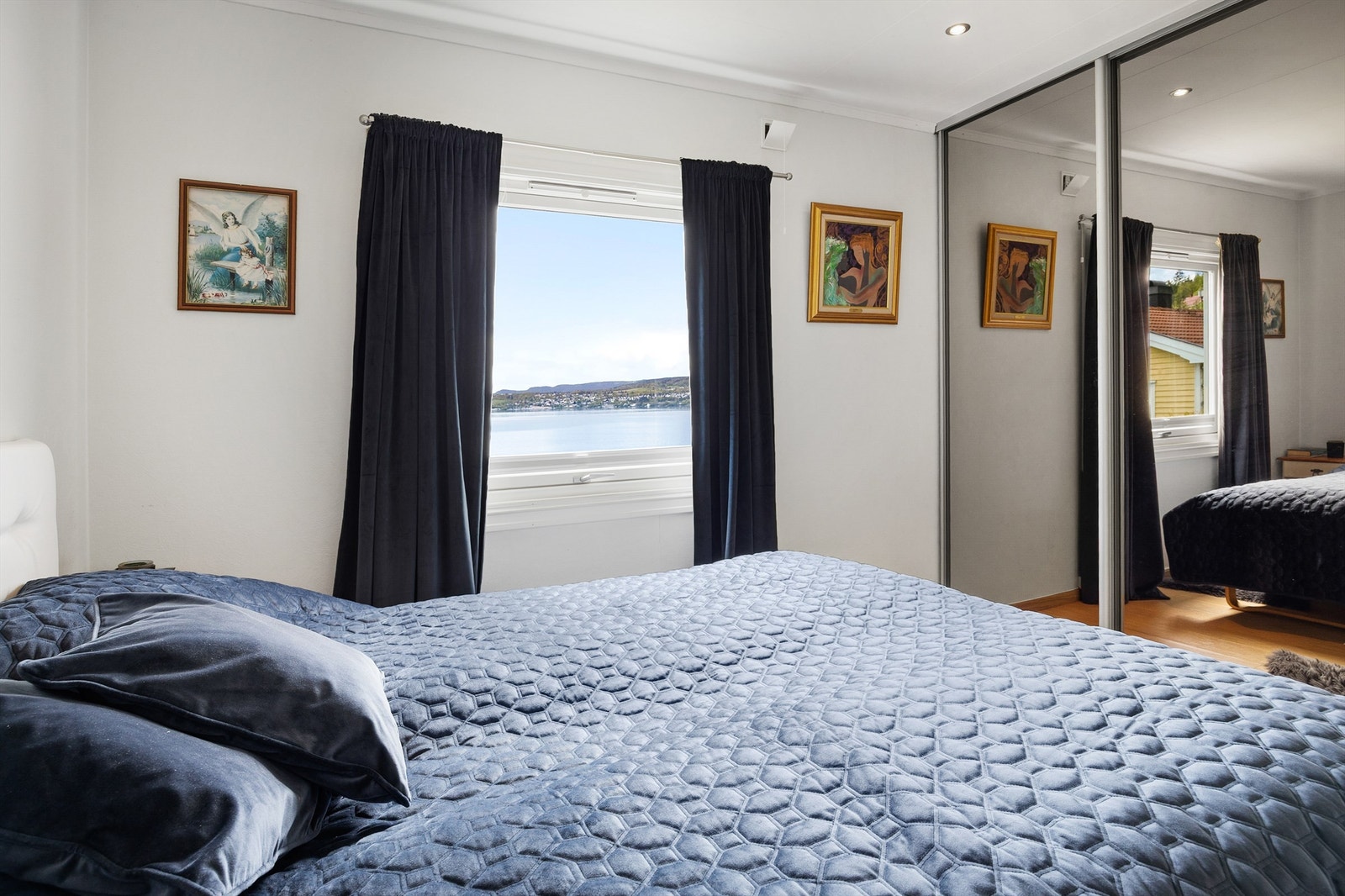 Hovedsoverom med skyvedørsgarderobe og utsikt mot fjorden. Galleribilde