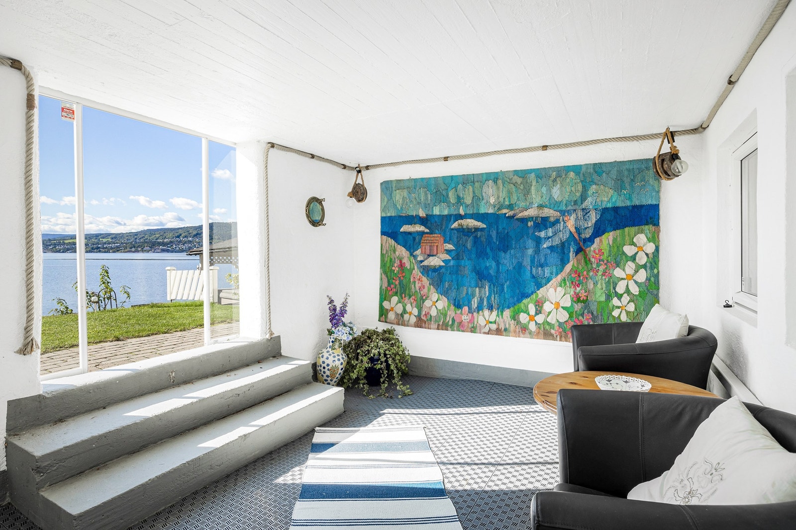 Innglasset terrasse i underetasjen med skyvedør i glass mot uteområdet. Galleribilde