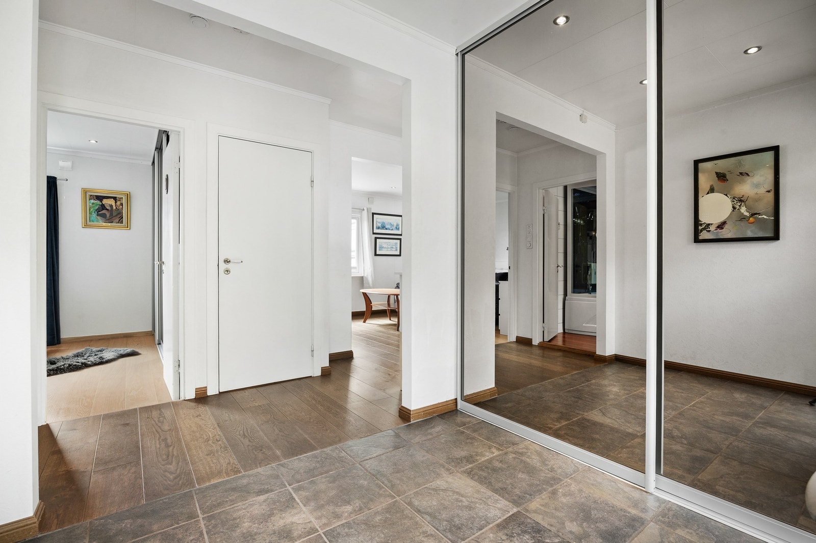 Entré med flislagt gulv, vannbåren gulvvarme og romslig skyvedørsgarderobe. Galleribilde