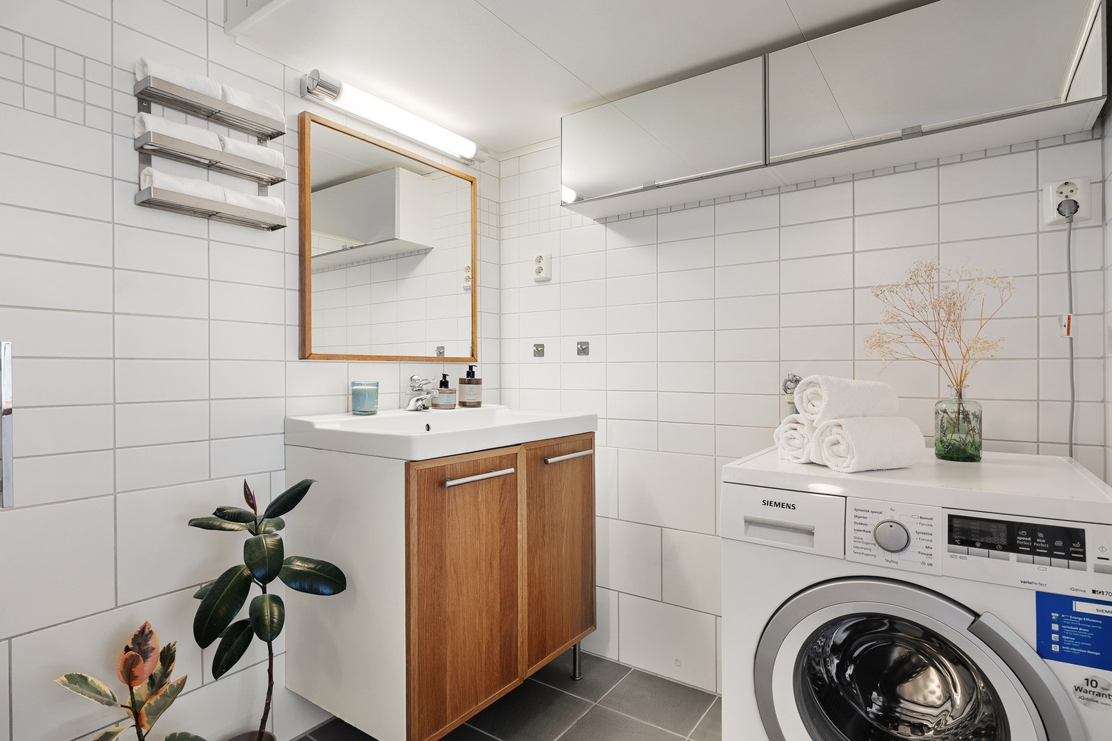På badet er det også opplegg for vaskemaskin. Vaskemaskinen kan også følge av kjøpet, ved ønske om det. Oppbevaringsplass i skap under servant samt i skap over vaskemaskin. Galleribilde