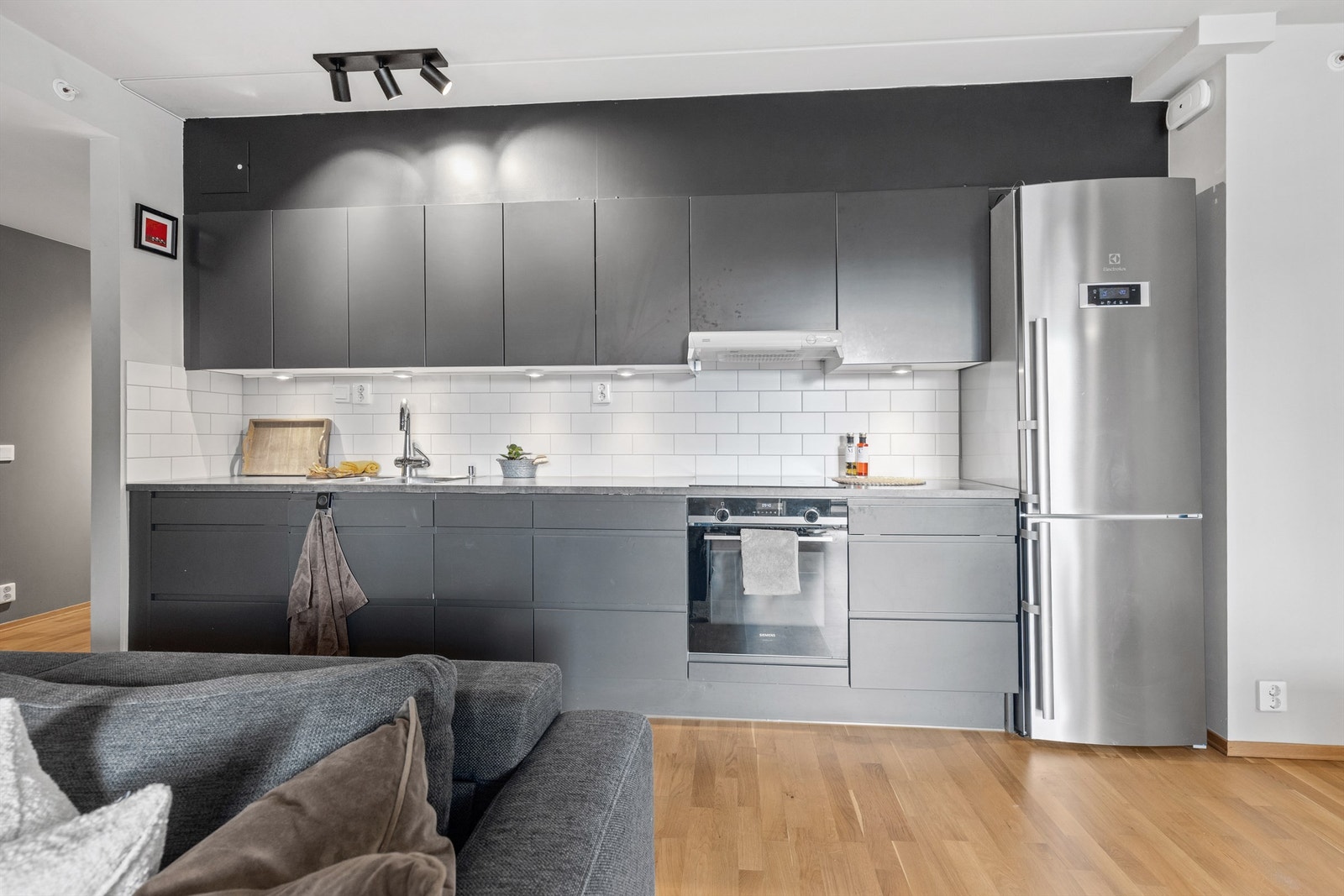 Kjøkkeninnredning fra JKE Design med glatte fronter og laminat benkeplate med nedfelt vaskekum. Galleribilde
