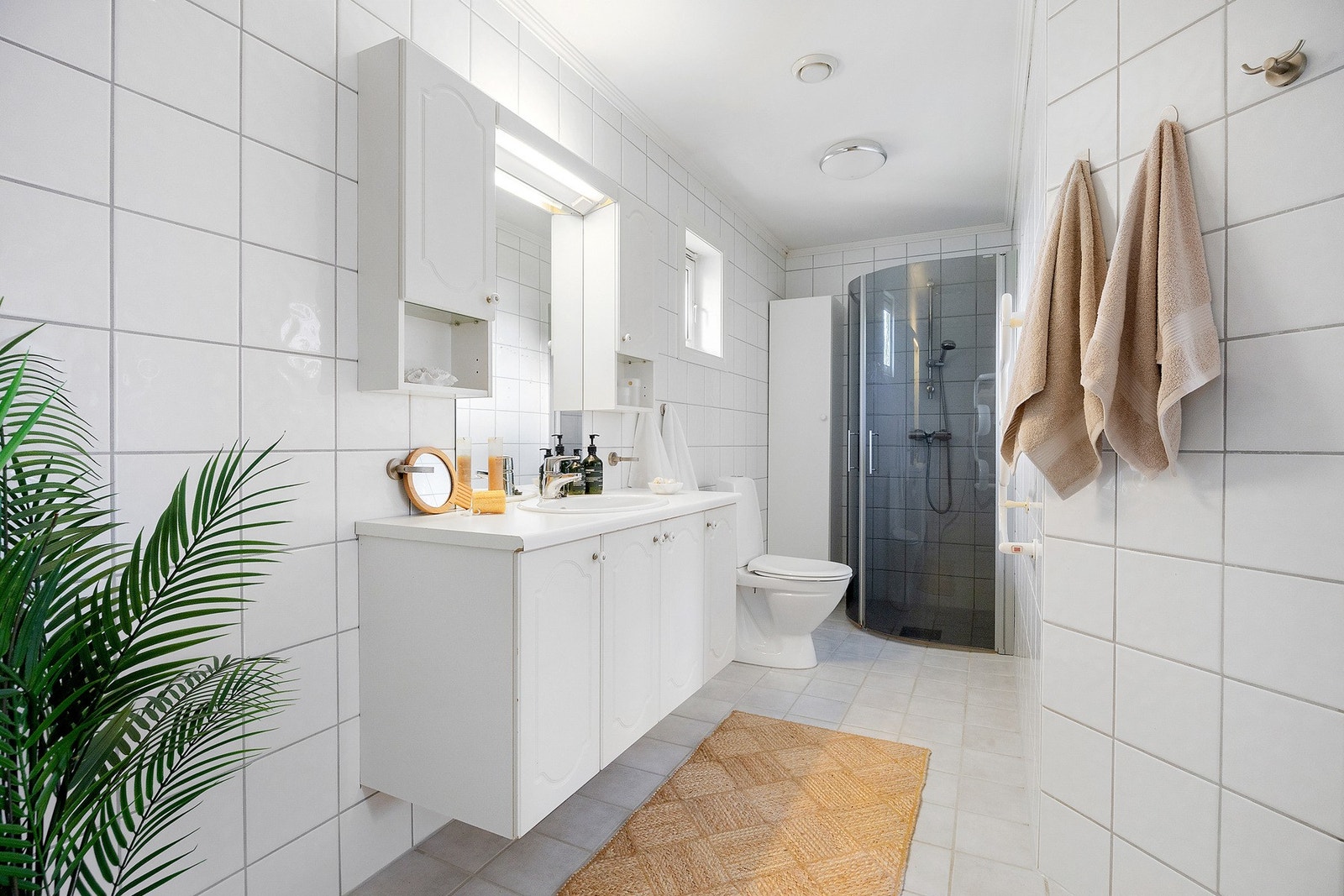 Flislagt bad med varmekabler i gulvet. Badet er innredet med toalett, dusjnisje, elektrisk håndkletørker, servant med innredning og har opplegg for vaskemaskin. Galleribilde